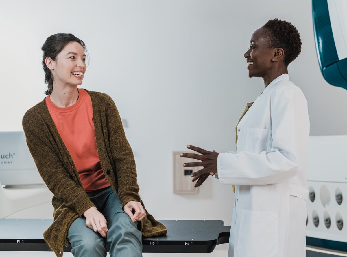 Smiling provider speaking with patient during a wellness visit, illustrating personalized care and trust.