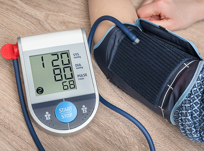 Patient using digital blood pressure monitor at home as part of chronic care management (CCM) services under CPT 99490, tracking systolic, diastolic, and pulse data for care coordination.