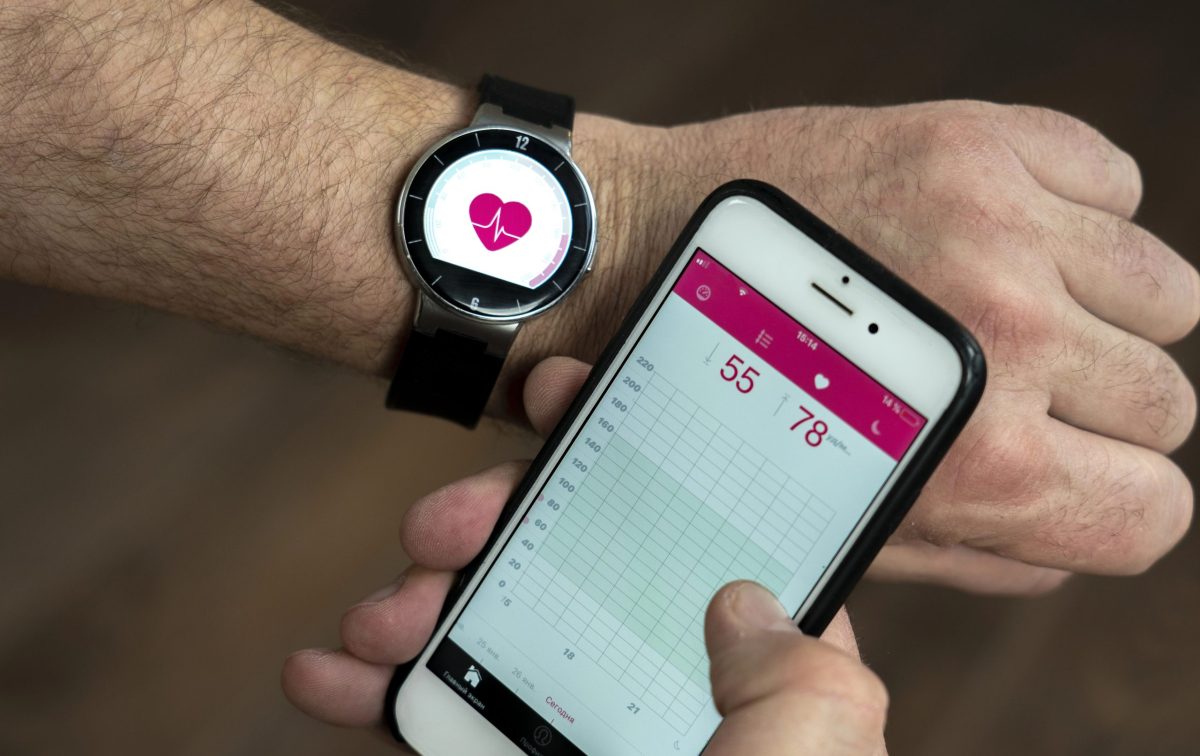 Remote therapeutic monitoring (RTM) smartwatch and smartphone showing real-time heart rate and health metrics.